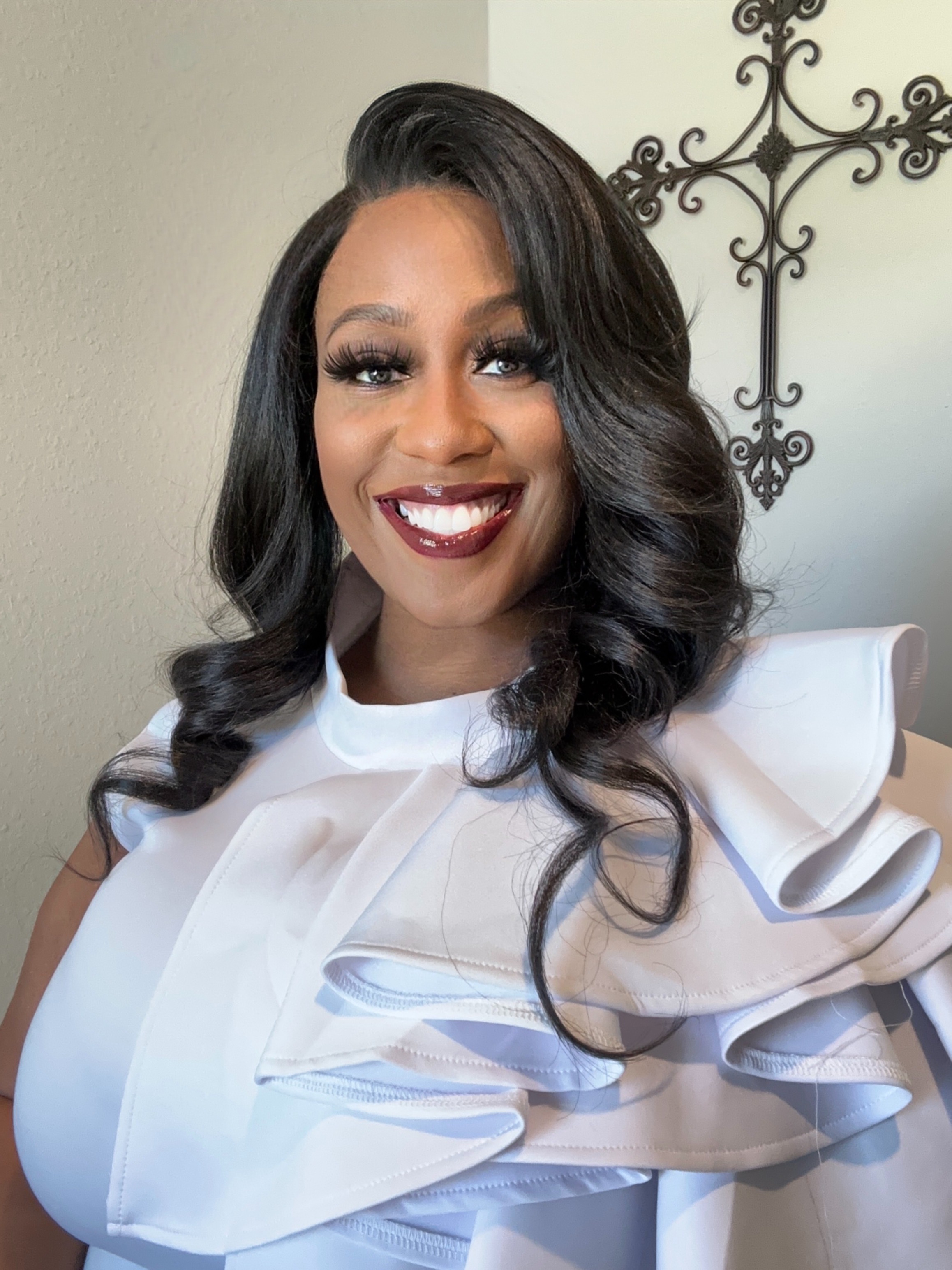 Shamarian Smith-Love smiling in front of a ornate iron cross